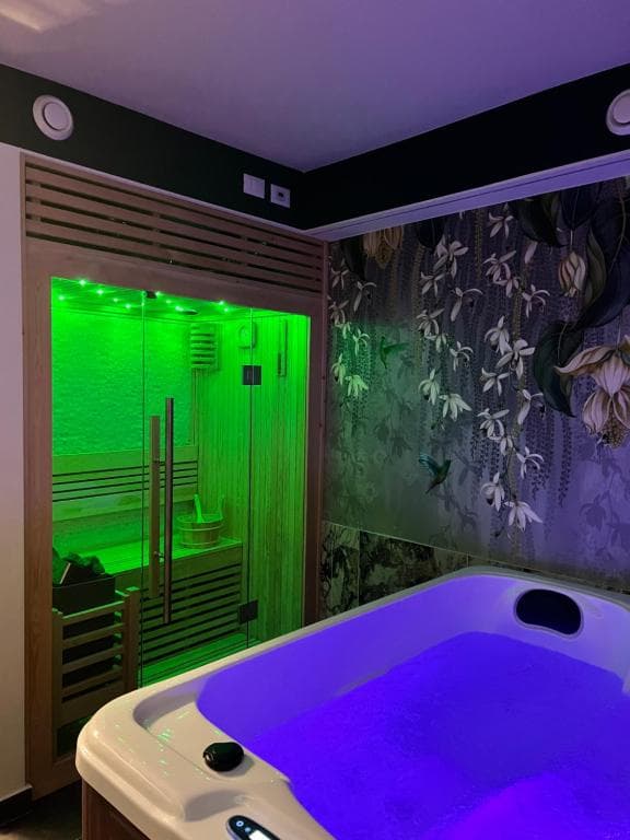SPA privata Marcello a Verona in atmosfera Acquamarina: sauna finlandese in cromoterapia verde brillante e vasca idromassaggio in cromoterapia viola, carta da parati botanica